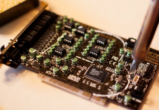 Carefully unsoldering the resistors, capacitors and other components in the way of the cut line.