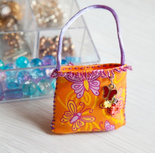 Tiny ribbon purse with charm dangle. 