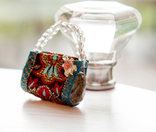 I used a tiny turtle from a pierced earring to embellish this miniature clutch purse.