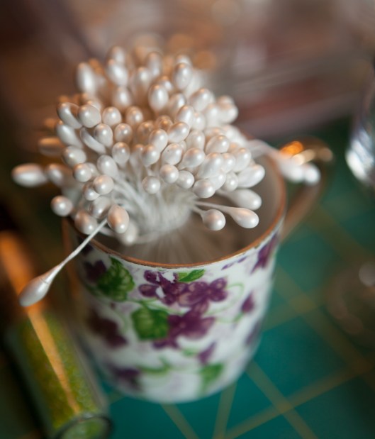 A small child's teacup holds white stamens.