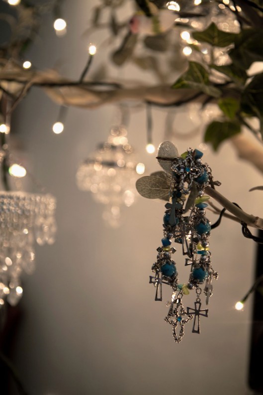 Chandelier ornaments and a bracelet hang from an artificial tree to light my new office space.