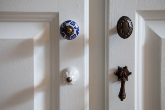 Mismatched knobs used in place of cabinet handles.