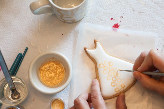 Painting the cookie with gold dust mixed with kirsch. 