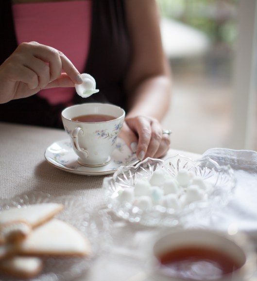 The birthday girl drops a little Sugar Bonnet in her cup of tea.