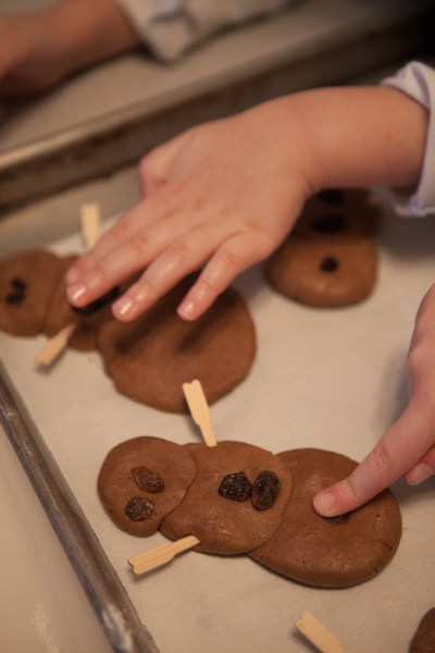 Gingerbread snowmen with wood pick arms and raisin buttons.